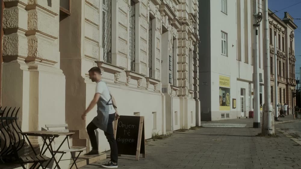 Barista vynáší áčko s nápisem „Opijem tě doppiem" před kavárnu