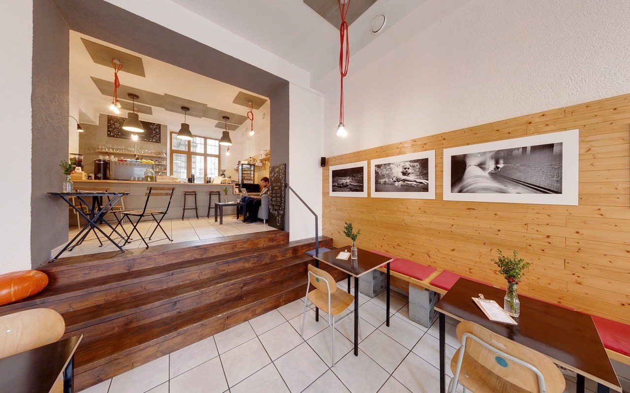 Interiér kavárny KAFE JAK LUSK na třídě Svobody v Olomouci – bar, dřevěné schody a posezení